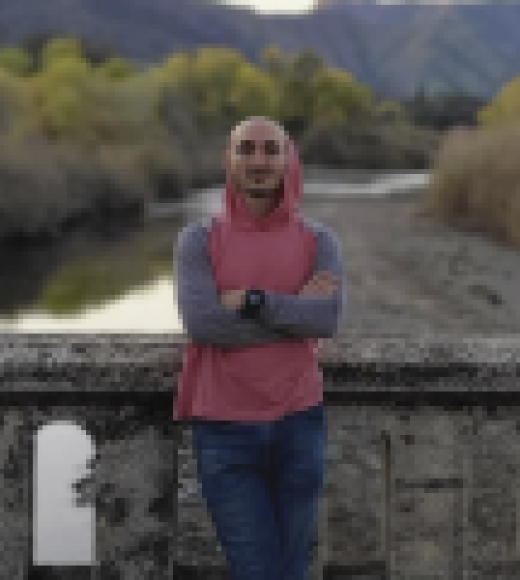 Beshara Kehdi stands in a red vest in front of a waterway.