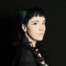 Jessica Bond is shown with black hair against a black background.